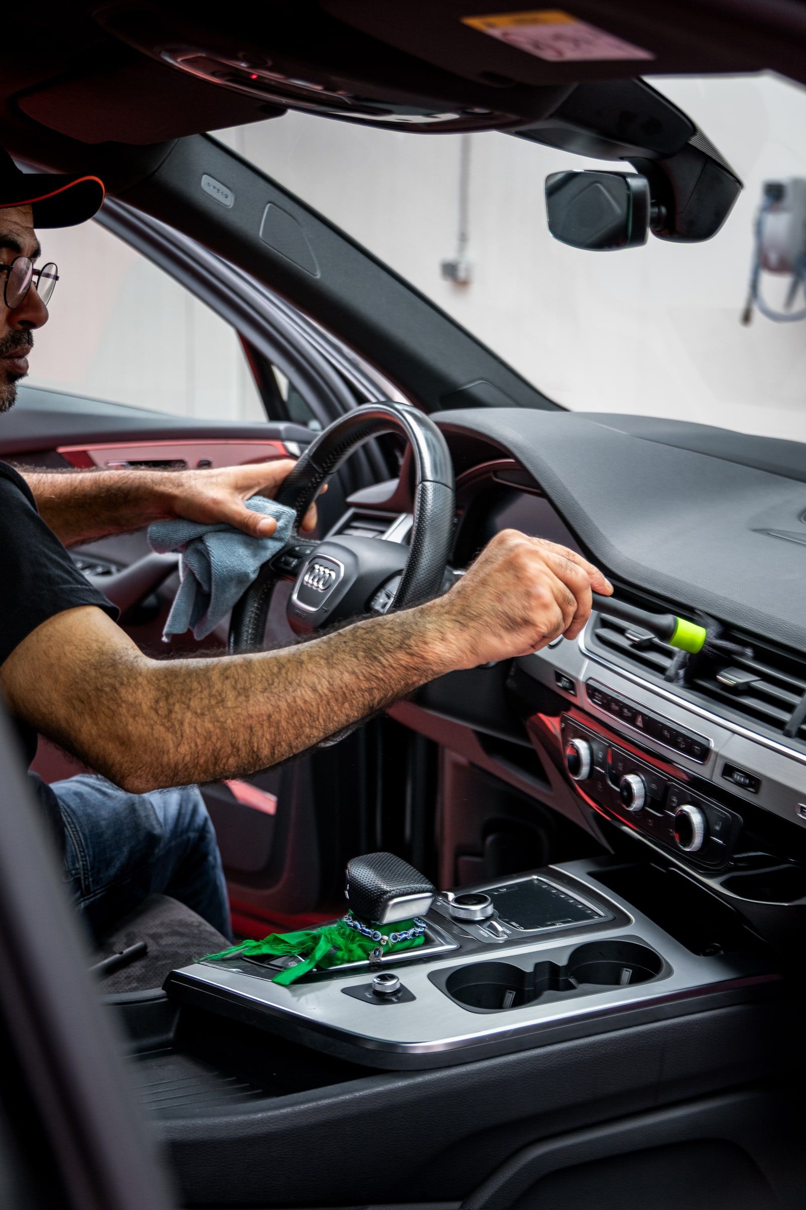 Lüftungsdüsen und Cockpit eines Autos werden bei emmi Carwash mit Pinsel und Tuch gereinigt
